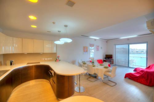 cocina y sala de estar con mesa y sillas en Bright and spacious 3 bedroom apartment with breathtaking views - GOSLM5, en Sliema