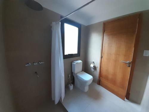 a bathroom with a toilet and a window and a shower at Laderas de Chacras vista Montaña en Barrio Privado in Chacras de Coria