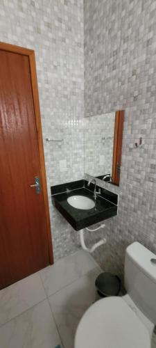 y baño con lavabo, aseo y espejo. en Suítes Guriri, en Guriri