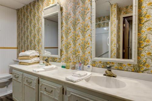 a bathroom with a sink and two mirrors at Melton Away - Knoxville/Oak Ridge in Knoxville