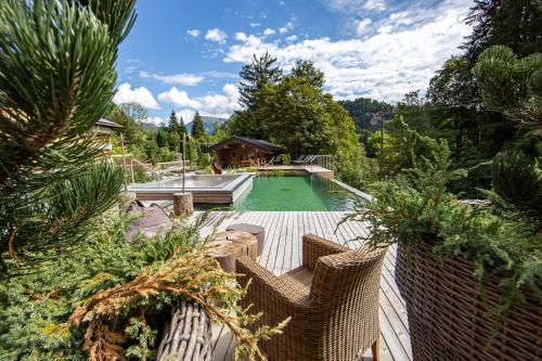 a swimming pool in a backyard with a house at Brunnenhof Oberstdorf - Ferienwohnungen mit Hotel Service in Oberstdorf