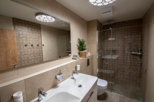 a bathroom with a sink and a toilet and a mirror at Apartmán Jesienka, Hillside in Dolný Kubín