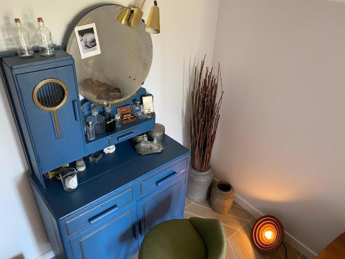 einen blauen Schrank mit einem Spiegel und einem Stuhl in der Unterkunft Ness Cottage, le calme absolu à 15 minutes des plages in Le Beausset