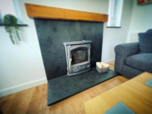 a fireplace in a living room with a couch at Mary Cottage, Braunton, Devon in Braunton