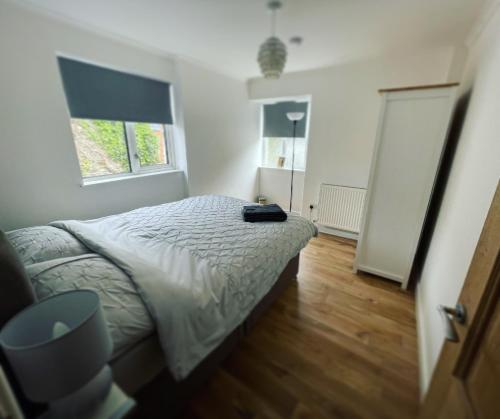 a bedroom with a bed and two windows at Mary Cottage, Braunton, Devon in Braunton
