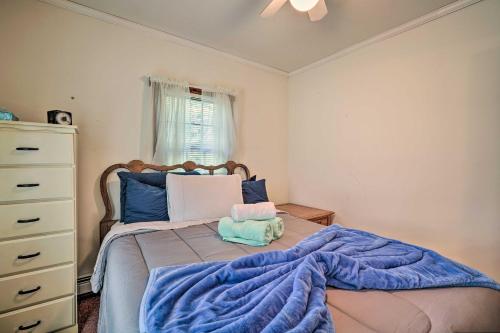 a bedroom with a bed with a blue blanket at Dog-Friendly Waretown Home with Furnished Deck! in Waretown