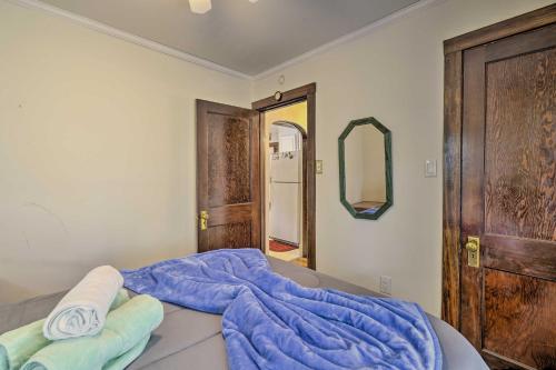 a bedroom with a bed with a blue blanket and a mirror at Dog-Friendly Waretown Home with Furnished Deck! in Waretown