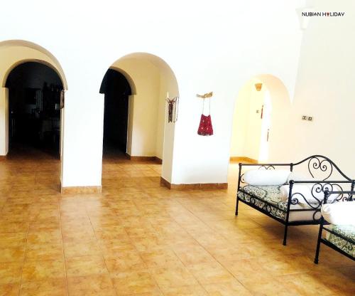 a room with two beds and a wooden floor at Nubian Holiday House Aswan in Aswan