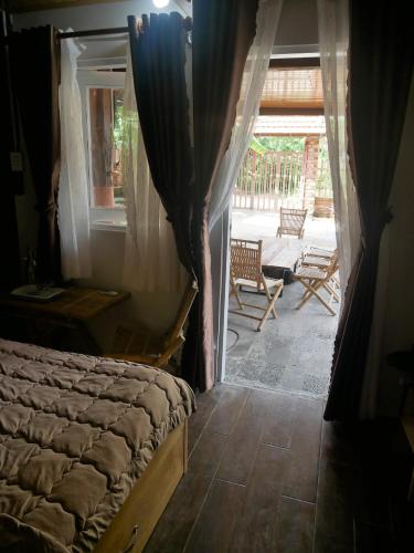 a bedroom with a bed and a view of a patio at Xô Xôn Homestay in Kon Rơbang