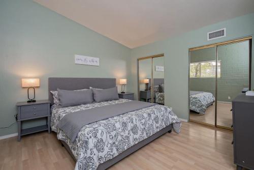 ein Schlafzimmer mit einem großen Bett und einem Spiegel in der Unterkunft Charming Condo in the Heart of Scottsdale in Scottsdale