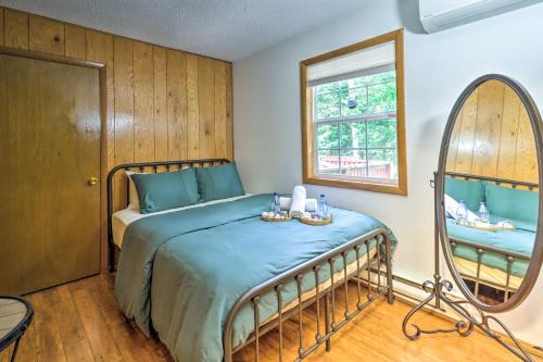 ein Schlafzimmer mit einem Bett und einem Spiegel in der Unterkunft Walk to Wolf Run Lake Cottage with Furnished Deck in Albrightsville