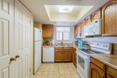 a kitchen with white appliances and wooden cabinets at Cozy 2 bedroom Condo with Golf Course views in Mesa