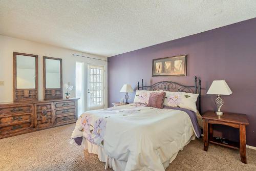 a bedroom with a large bed and a purple wall at Cozy 2 bedroom Condo with Golf Course views in Mesa