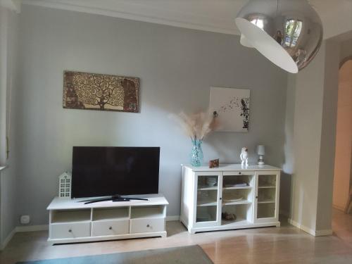 a living room with a tv and a white cabinet at La Casa Bianca in Parma
