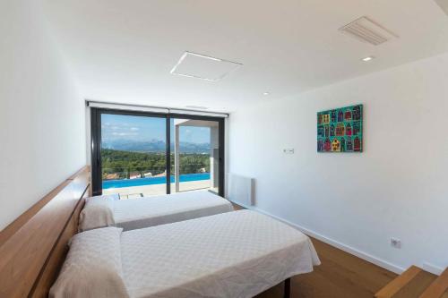 a bedroom with two beds and a large window at Villa Panoramica by Esteva Emerald Stay in Cielo de Bonaire 
