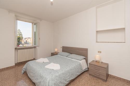 een witte slaapkamer met een bed en een raam bij Appartamento Piazza Garibaldi - F&L Apartment in Brescia
