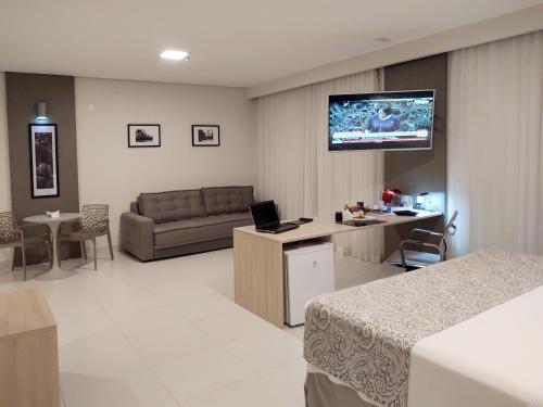 a hotel room with a couch and a tv on the wall at TRYP by Wyndham Manaus Aeroporto in Manaus