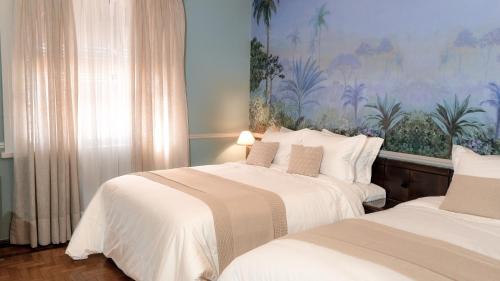 a bedroom with two beds and a painting on the wall at Grande Hotel Termas de Araxá in Araxá