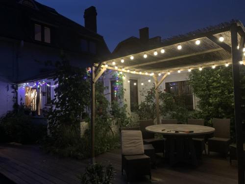 a patio with a table and string lights at night at Gîte: À la courbe du fleuve in Godinne