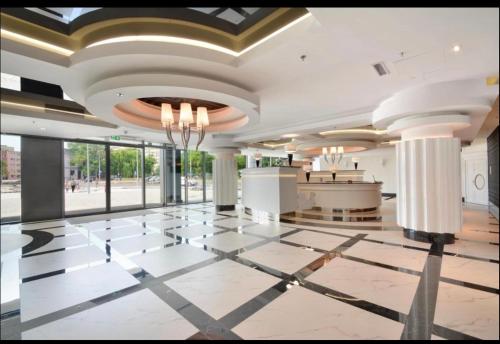 a lobby with a marble floor and a chandelier at Hanza Tower De Lux apartament in Szczecin