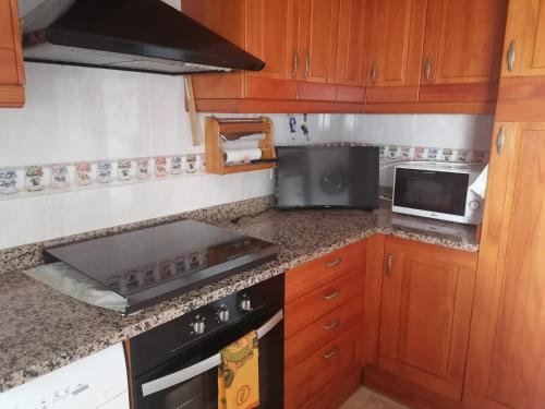 uma cozinha com um fogão e um micro-ondas em Dúplex en el centro del pueblo, muy bien comunicado em Puigcerdà
