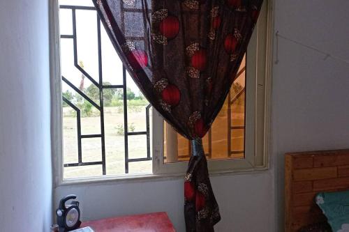 a window with a curtain in front of it at Beach House in Kigamboni Dar es Salaam in Dar es Salaam