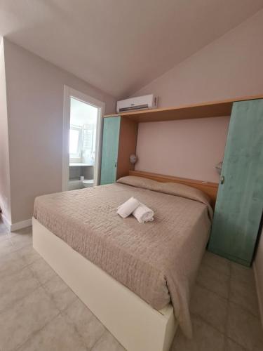 a bedroom with a bed with a towel on it at Hotel La Buca Del Gatto in Marina di Cecina
