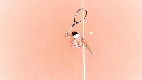 a woman hitting a tennis ball with a racquet at Grande Hotel Termas de Araxá in Araxá