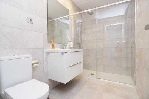 een witte badkamer met een douche en een toilet bij Blossom Benalmádena Pueblo in Benalmádena