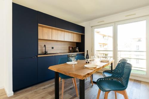 une cuisine avec une table en bois et des armoires bleues dans l'établissement DIFY Bourbonnais - Quartier Vaise, à Lyon