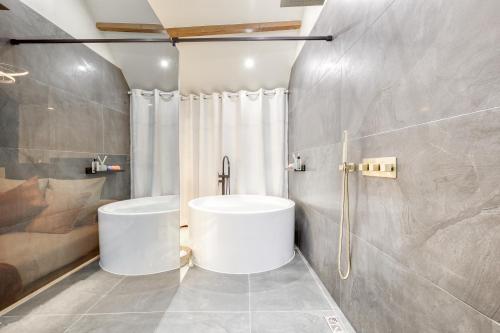 uma casa de banho com uma banheira branca e um chuveiro em Swim&Chill By Weloveyou em Cormeilles-en-Parisis