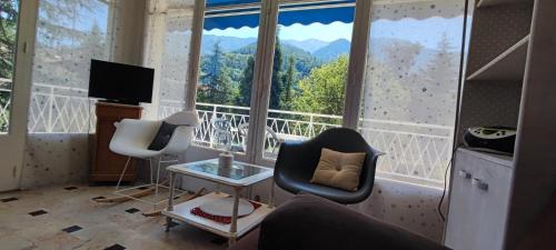 - un salon avec deux chaises et une grande fenêtre dans l'établissement Refuge Arago, à Vernet-les-Bains