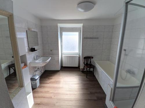 ein Bad mit einer Badewanne, einem Waschbecken und einer Dusche in der Unterkunft Hotel Rath in Schwalmtal