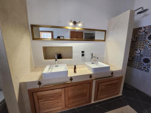 een badkamer met 2 wastafels en een spiegel bij AdaZen Ecolodge in Azilal