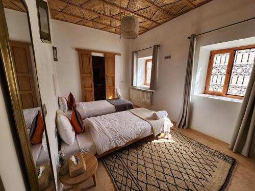 een slaapkamer met een groot bed in een kamer met ramen bij AdaZen Ecolodge in Azilal