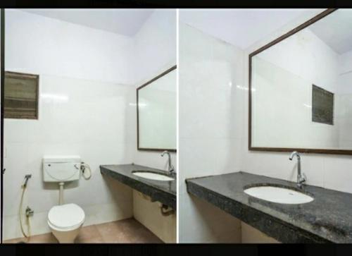 a bathroom with two sinks and a toilet and a mirror at Hotel Ranjit Residency in Hyderabad