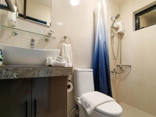 a bathroom with a sink and a toilet and a shower at Manzil Anilao B&B in Mabini