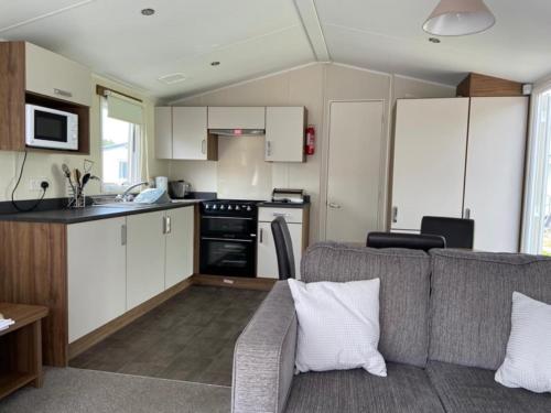 a living room with a couch and a kitchen at Adams Caravan Holidays in Morecambe