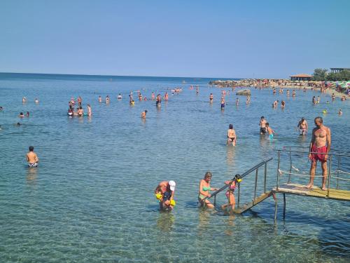 a group of people in the water at a beach at Hotel La Buca Del Gatto in Marina di Cecina