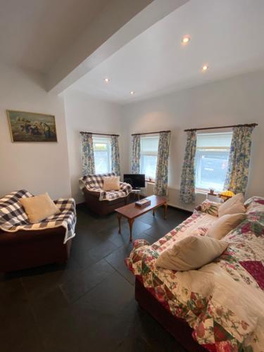 a living room with two beds and a couch at Tranquil 2 Bedroom Cottage With Hot Tub Sea View Teach Cha in Sessiagh