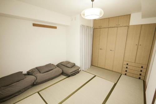 een woonkamer met een bank in de hoek van een kamer bij Bios Hall / Vacation STAY 2175 in Sapporo
