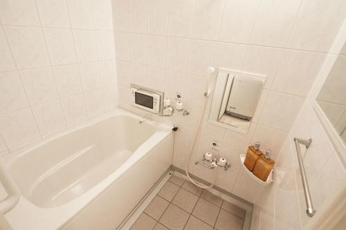 een witte badkamer met een bad en een wastafel bij Bios Hall / Vacation STAY 2175 in Sapporo