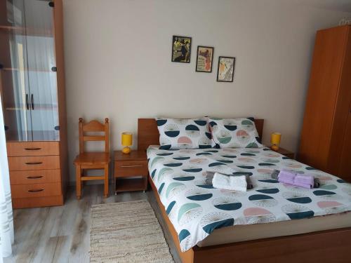 a bedroom with a bed and a chair at Apartmani MALINA in Vrnjačka Banja