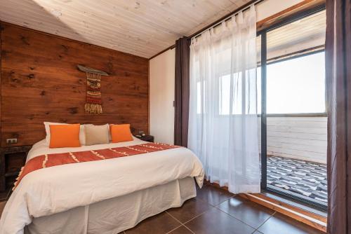 um quarto com uma cama e uma grande janela em Pichilemu Apart Hotel em Pichilemu