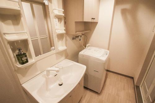 a bathroom with a sink and a washer and dryer at Bios Hall / Vacation STAY 2181 in Sapporo