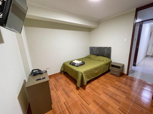 a bedroom with a bed and a television and a wooden floor at Apart La Merced in Caraz