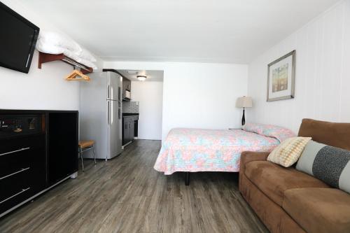 a bedroom with a bed and a couch in a room at Olympic Island Beach Resort in Wildwood Crest