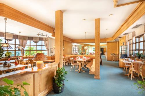 a restaurant with tables and chairs and windows at Hotel Forstmeister in Schönheide