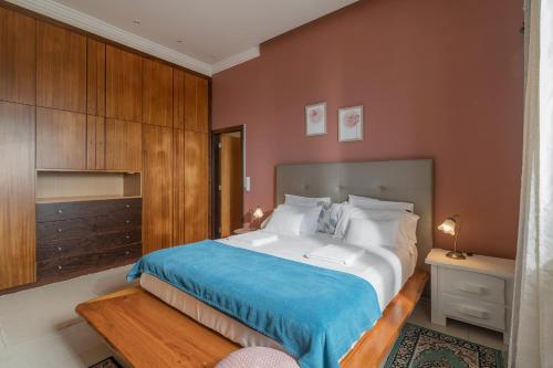 1 dormitorio con 1 cama grande con manta azul en Villa Sea Colors by An Island Apart, en Arco da Calheta