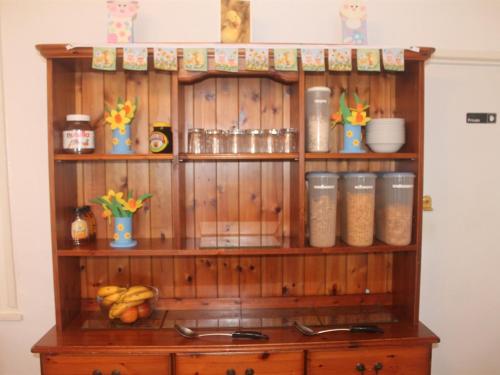 a wooden shelf with food items on top of it at Carnson House in Penzance